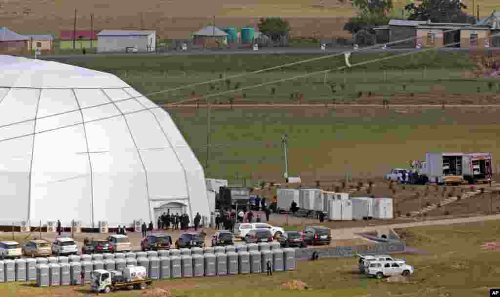 People stand outside the dome where the funeral of former South African president Nelson Mandela is taking place in Qunu.