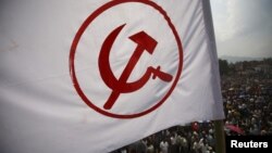 A party flag of the Unified Communist Party of Nepal (Maoist) flutters above the crowd during a mass gathering in Kathmandu, June 15, 2012. 