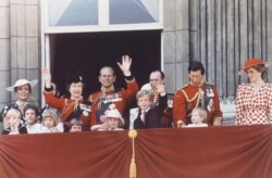 Ratu Inggris Elizabeth II dan Pangeran Philip melambaikan tangan mereka kepada publik di luar istana Buckingham, London, 14 Juni 1986, setelah upacara "Trooping the Color", bersama Pangeran Charles dan Putri Diana serta anggota keluarga kerajaan lainnya.