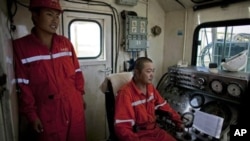 Chinese technicians operate drilling equipment on an oil rig in Paloich, southern Sudan, Nov 17, 2010