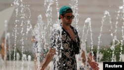 Un turista se refresca en una fuente pública en Lisboa, Portugal, el 4 de agosto de 2018. REUTERS/Rafael Marchante. Una ola de calor en Europa con temperaturas históricas ha comenzado a ceder, pero ha provocado sequía y fuegos en varios países, y en la región Algarve de Portugal.