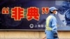 City employee wearing protective mask walks past local government anti-SARS advertisement, Shanghai, Dec. 29, 2003.