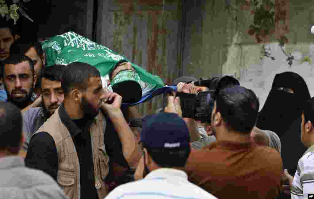 Palestinian relatives carry the body of a Hamas militant killed in an Israeli airstrike during his funeral in Jabaliya, Gaza Strip,October 24, 2012.