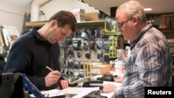 Brian O'Connor (L) of Newtown, Connecticut, fills out paperwork to purchase a Glock 10mm pistol at Chris' Indoor Shooting Range in Guilford, Connecticut April 2, 2013. 