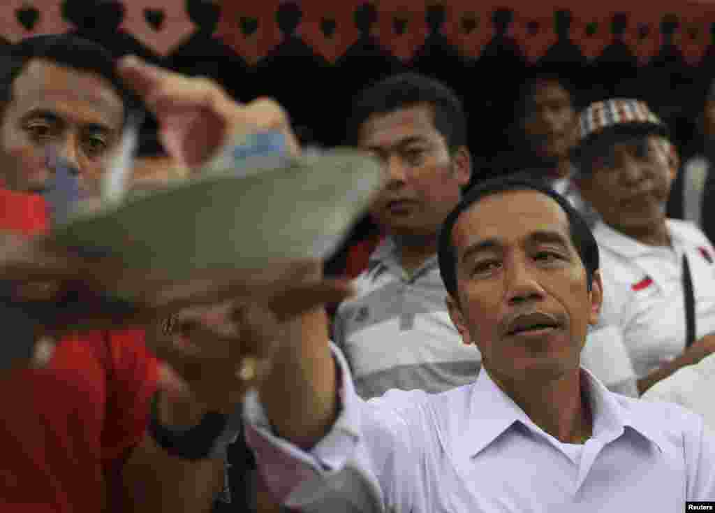 Jakarta governor and presidential candidate Joko Widodo gives donations during lunch with his supporters from the PDI-P party in Jakarta, March 16, 2014. 