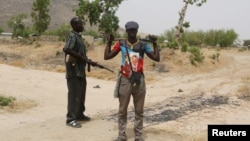 FILE - Members of a civilian vigilante group stand guard at the border with Nigeria in Kerawa, Cameroon, March 16, 2016. 