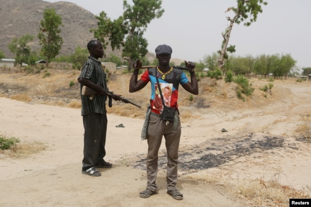 FILE - Members of a civilian vigilante group stand guard at the border with Nigeria in Kerawa, Cameroon, March 16, 2016. Kerawa is on the border with Nigeria and is subject to frequent Boko Haram attacks.