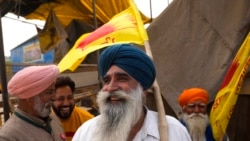 Farmers celebrate news of the repeal of farm laws they were protesting against, in Singhu, on the outskirts of New Delhi, India, Nov. 19, 2021.