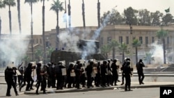 Polisi anti-huru-hara menembakkan gas air mata ke arah para pendukung Ikhwanul Muslimin dalam sebuah demonstrasi di Cairo University, Mesir (20/5). (AP/Ahmed Gamil)