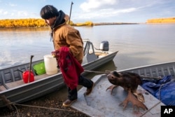 Steven Guinness Jr., 14, carries his hunting rifle into the village after returning from the Stevens family hunting camp, Sept. 15, 2021, in Stevens Village, Alaska. A new bill would allow Native Americans to use tribal IDs to buy guns.