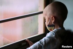 Manuel Andres Sequera, 2, melihat ke luar jendela saat melakukan kemoterapi di rumah sakit anak. (Foto: Reuters)