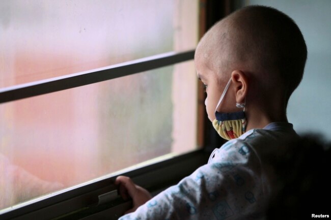Manuel Andres Sequera, 2, melihat ke luar jendela saat melakukan kemoterapi di rumah sakit anak. (Foto: Reuters)
