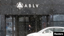 A security guard speaks on her mobile phone at the head office of the ABLV Bank in Riga, Latvia Feb. 18, 2018.