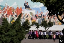 North Koreans youths march in a group past a mural as the capital prepares for the 70th anniversary of North Korea's founding day in Pyongyang, North Korea, Sept. 7, 2018.