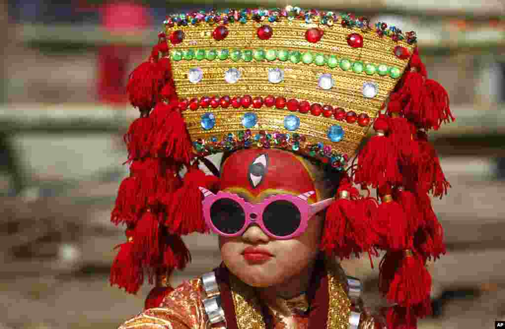 A Nepalese girl dressed as living goddess Kumari waits for Kumari Puja at Hanuman Dhoka, Basantapur Durbar Square in Kathmandu.