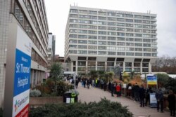 People queue outside a COVID-19 vaccination center at St Thomas's Hospital in London, Britain, Dec. 13, 2021.