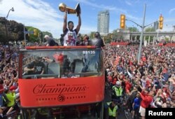 Toronto Raptors guard Kyle Lowry and teammates show off their trophy to fans during a parade through downtown Toronto to celebrate their NBA title, June 17, 2019.