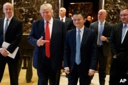 President-elect Donald Trump stands with Alibaba Executive Chairman Jack Ma as they walk to speak with reporters after a meeting at Trump Tower in New York, Jan. 9, 2017.