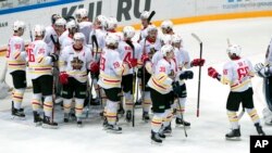 FILE - Kunlun Red Star's team players celebrate after they won the Kontinental Hockey League match against Spartak Moscow, Oct. 1, 2016, in Moscow, Russia.