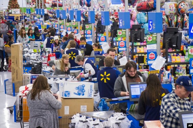 FILE - Customers wrap up their holiday shopping during Walmart's Black Friday events in Bentonville, Ark., Nov. 27, 2014.