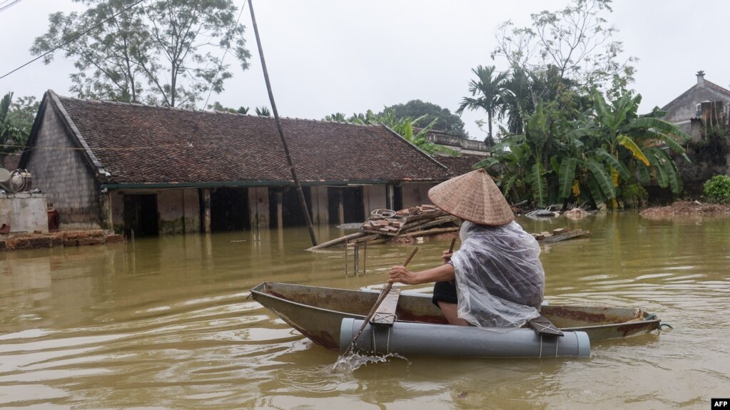 Một dân làng chèo xuồng giữa nước lụt.