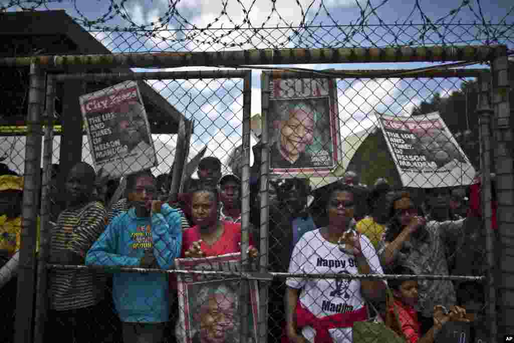 Mourners line up after waiting for hours to get into a bus to go to the Union Buildings where the casket of Nelson Mandela lies in state for three days in Pretoria, Dec. 11, 2013.