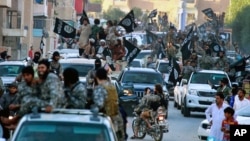 Fighters from the Islamic State group parade in Raqqa, north Syria, in June 30, 2014