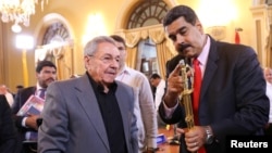 FILE - Venezuela's President Nicolas Maduro, right, shows a sword of Venezuelan national hero Simon Bolivar to Cuba's President Raul Castro in Caracas, Venezuela, March 5, 2017. 