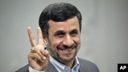 Iranian President Mahmoud Ahmadinejad gestures to the media as he attends for an official meeting with Qatar's Foreign Minister Adviser Khalid Mohammad al-Atiyeh, in Tehran, October 13, 2011.