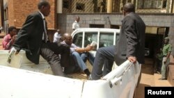 FILE: Zimbabwean pastor Evan Mawarire reads a bible as he arrives escorted by detectives at the Harare Magistrates court, Zimbabwe, Feb. 3, 2017.