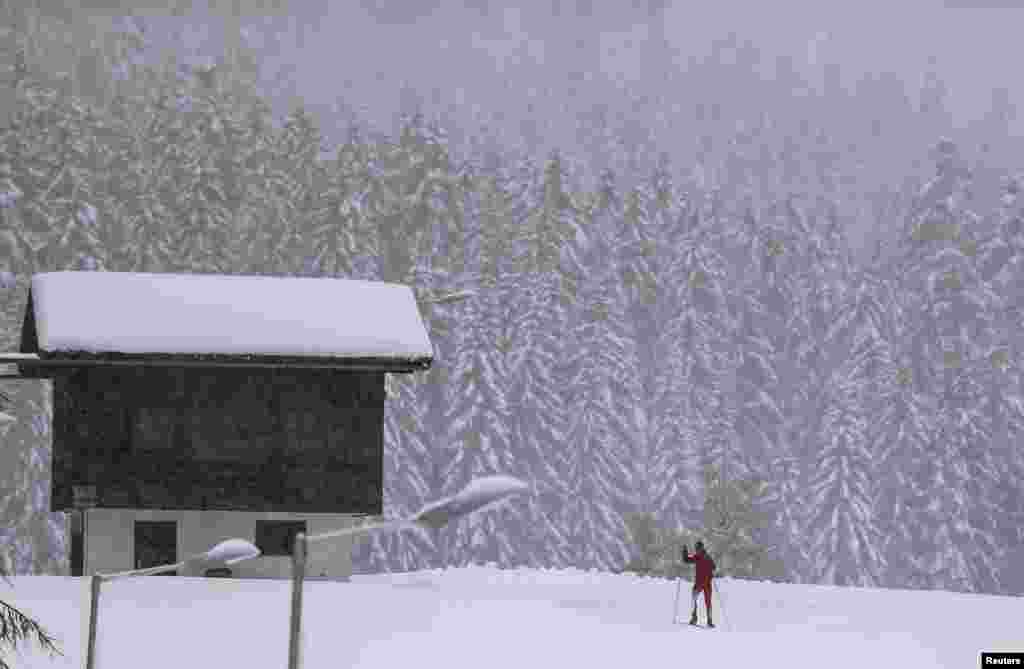 A cross-country skier skis on a snow-covered field in the western Austrian village of Seefeld, following the first snowfall of the season. 