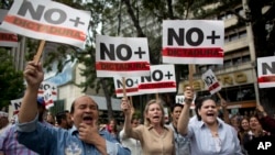Người biểu tình chống tổng thống Maduro mang biểu ngữ có dòng chữ "Chấm dứt độc tài", Caracas, 30 tháng Giêng.