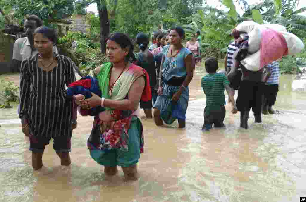 Nepalese villagers carry their belongings as they move to safer ground, in Bardia, western Nepal, Aug. 15, 2014.