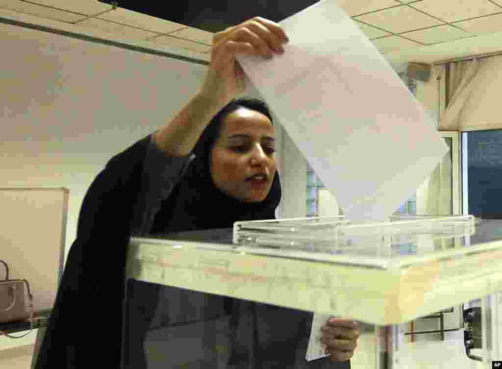 Seorang perempuan Saudi memasukkan kertas suaranya di TPS saat pemilihan dewan kota di Riyadh, Arab Saudi, 12 Desember 2015.