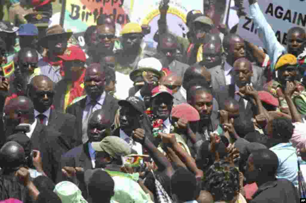 Zimbabwean President Robert Mugabe, center, greets the crowd as he arrives for his 88th birthday celebrations in Mutare, Zimbabwe Saturday, Feb. 25, 2012.