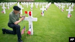 Mark Shively, dari Beaverton, Oregon meninggalkan bunga di makam kakeknya, seorang marinir AS yang gugur pada Perang Dunia I, di taman makam pahlawan Belleau, Perancis (26/5). 