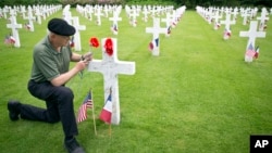 Mark Shively, from Beaverton, Oregon leaves flowers at the grave of his grandfather's unit commander, World War I U.S. Marine Corps Lt. Carleton Burr, during Memorial Day weekend at Aisne-Marne American Cemetery in Belleau, May 26, 2018.