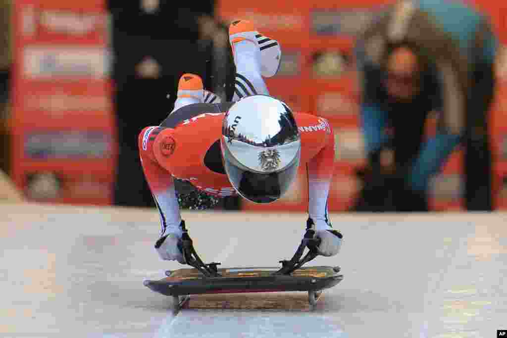 Austria&#39;s Janine Flock jumps on her skeleton during her first run in the women&#39;s Skeleton World Cup race in Innsbruck, Austria. 