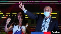 El candidato presidencial chileno José Antonio Kast gesticula junto a su esposa Maria Pia Adriasola Barroilhet mientras habla luego de los resultados parciales de la primera vuelta durante las elecciones presidenciales, en Santiago, Chile, el 21 de noviembre de 2021.