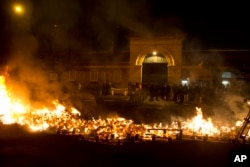 FILE - Prison guards protest by burning pallets outside Fresnes prison, outside Paris, France, Jan. 24, 2018.