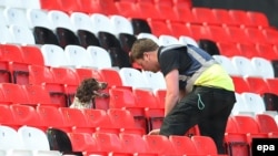 Des chiens renifleurs cherchent des objets suspects après l’évacuation des spectateurs, avant le match de football de la première ligue anglaise entre Manchester United et Bournemouth à Old Trafford, à Manchester, Grande-Bretagne, 15 mai 2016. epa/ PETER