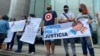 Jóvenes sostienen carteles con mensajes a favor de la justicia durante una concentración en la sede el Programa de las Naciones Unidas para el Desarrollo en Caracas antes de la llegada del fiscal de la CPI, Karim Khan. Octubre 29, 2021. Foto: Adriana Nuñez Rabascall - VOA.