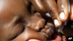 A baby receives a polio vaccine in Nigeria.