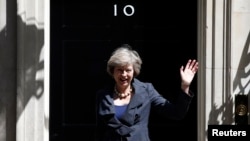 Theresa May waves as she leaves after a cabinet meeting at number 10 Downing Street in central London, July 12, 2016.
