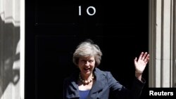 Britain's new Prime Minister Theresa May waves as she leaves after a Cabinet meeting at number 10 Downing Street in central London on July 12, 2016. 