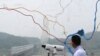 FILE - A man watches the north side through the glass showing a map of the border area between North and South Koreas at the Imjingak Pavilion near the Panmunjom, which has separated the two Koreas since the Korean War, in Paju, South Korea, July 6, 2017.