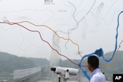 FILE - A man watches the north side through the glass showing a map of the border area between North and South Koreas at the Imjingak Pavilion near the Panmunjom, which has separated the two Koreas since the Korean War, in Paju, South Korea, July 6, 2017.