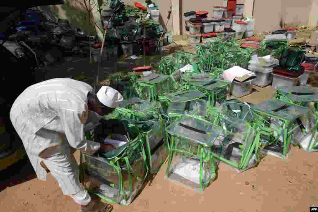 An official of the Independent National Electoral Commission retrieves documents from presidential election ballot boxes in Katsina state. Nigeria's closely fought general elections were forced into a second day after failures in controversial new technology snarled the polling, including for President Goodluck Jonathan.
