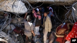 FILE - People search for survivors in the rubble of a house destroyed by Saudi-led airstrikes that killed a TV director, his wife and three children in Sanaa, Yemen, Feb. 10, 2016.