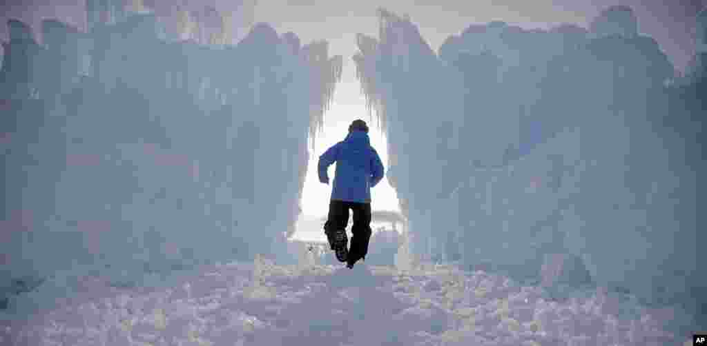 A worker walks through the Ice Castles during final preparations in Midway, Utah, Dec. 27, 2016. Hundreds of thousands of icicles make up the 20-foot walls, jagged mazes and fountains of the castle.